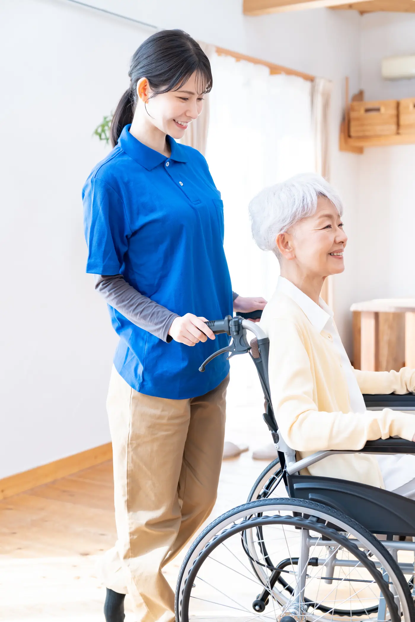 自宅で高齢の女性を支える介護スタッフ